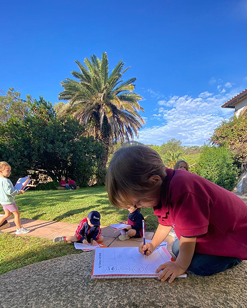 Early years boy drawing in the forest